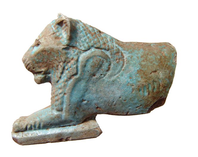 An Egyptian faience inlay of a lion, Ex Lord Kitchener: A choice Egyptian faience inlay of a lion, Ptolemaic, c. 3rd - 2nd Century BC, nicely detailed with strong light blue color, backside flat. L: 7 cm. Some losses to hind quarters and light deposits. Ex
