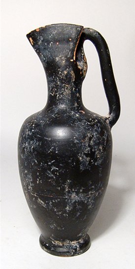 A Greek black-glazed Oinochoe, Campania: A Greek black-glazed Oinochoe, Campania, c. 4th Century BC, the ovoid body tapering to a wide disk foot with concave bottom, the mouth with "V-Shaped' pouring spout, the back cut away with single hand