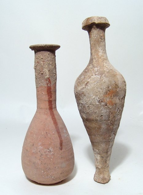 A lot of 2 tall Roman ceramic bottles: A lot of 2 tall Roman ceramic bottles, 1st - 2nd Century AD. The first is a large and elegant Roman piriform Unguentarium, orange buff, with long tubular neck and flattened rim. The elegant vessel sit