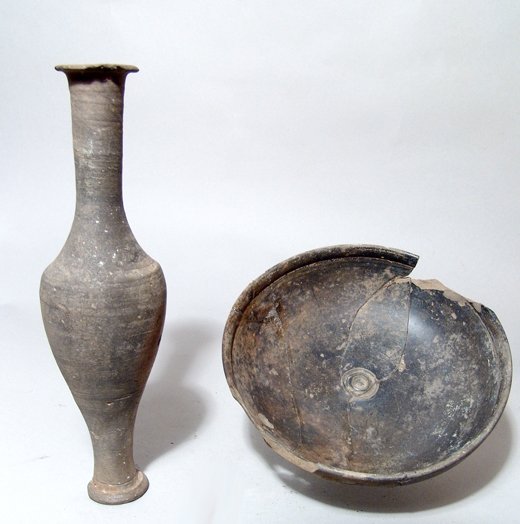 Phrygian ceramic bowl and a Roman spindle bottle: A Phrygian ceramic bowl and a Roman spindle bottle. The Phrygian bowl, Anatolia, c. 7th - 6th Century BC, with glossy grey-brown slip and incised design, (Dia: 5 7/8", 14.9 cm). Repaired with losses. 