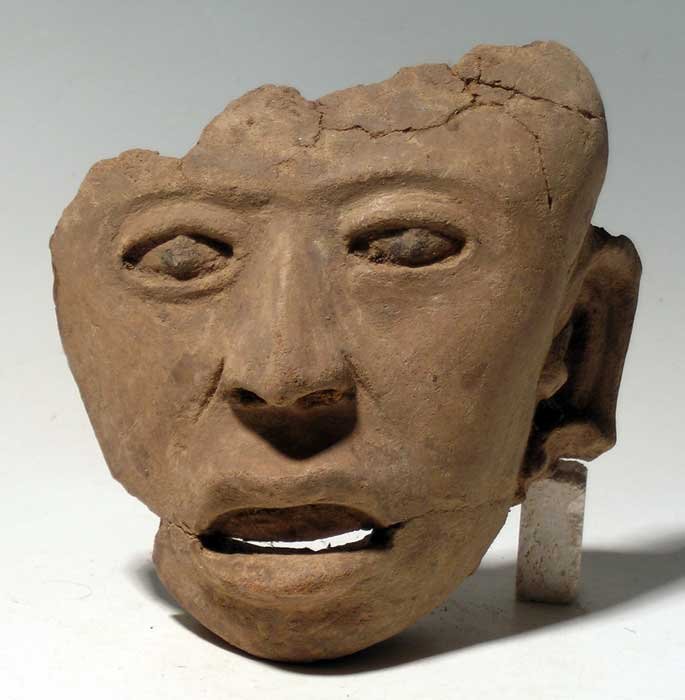A choice Vera Cruz head or mask fragment: A choice Vera Cruz head or mask fragment from Mexico, c. 300 - 900 AD. This beautifully sculpted piece is 5" high and depicts an individual with teeth showing in the open mouth. The pupils are created