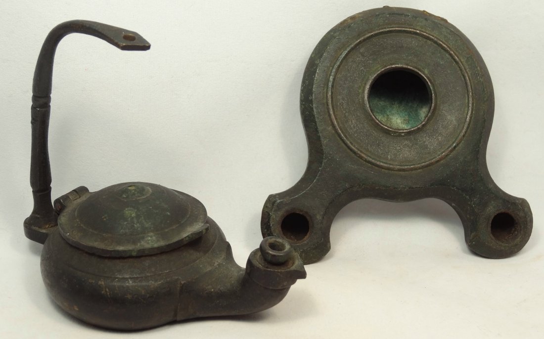 A lot of 2 Grand Tour oil lamps: A lot of 2 Grand Tour oil lamps. The first a bronze double-spouted lamp, late 19th Century. L: 10.9 cm; W: 7.3 cm. The second a bronze lamp, late 19th Century, with hinged center and tall handle. L: 1