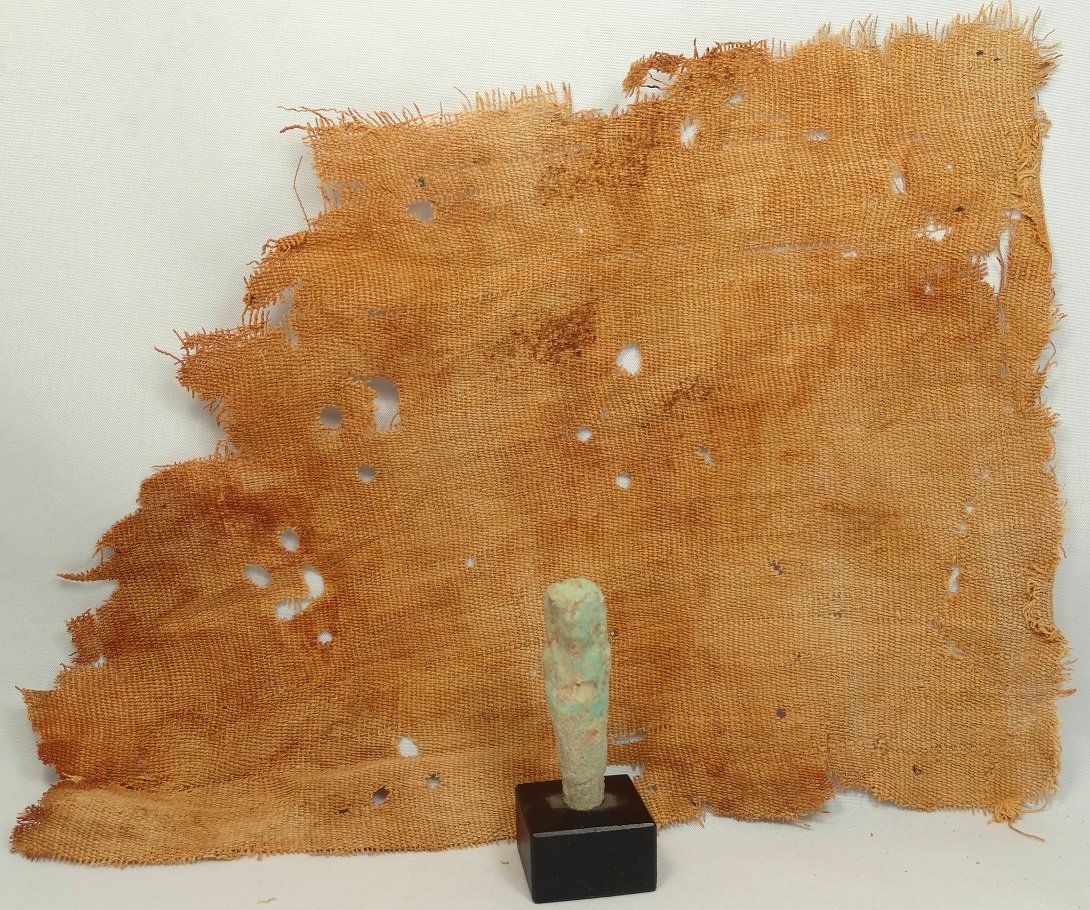 A lot of 2 Egyptian items: A lot of 2 Egyptian items. The first a light green ushabti, Ptolemaic, c. 305 - 30 BC, H: 1 7/8 in (4.9cm), frontally molded and mummiform, wearing tripartite headdress, arms folded across chest, hand