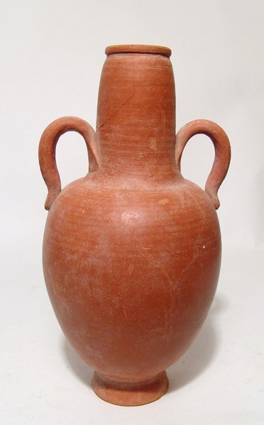 A Roman orange-ware bottle: A Roman orange-ware bottle, North Africa, c. 3rd - 4th Century AD, the body ovoid with flared foot, neck tapering to a narrow mouth with flat rim, a loop handle to either side. H: 22 cm. Intact, minor