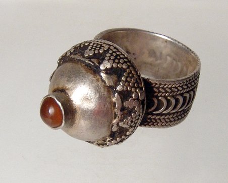 A European silver ring, 15th-16th Century: A European silver ring, c. 15th - 16th Century, the shank and edges of the highly domed bezel decorated with filigree, a small carnelian cabochon at its summit. Intact with nice tone. H: 3.8 cm, ring 