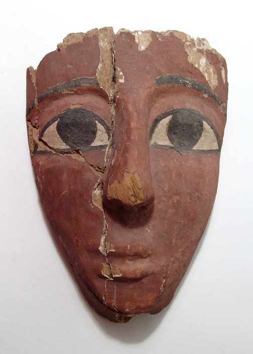 An Egyptian wood sarcophagus mask: An Egyptian wood sarcophagus mask, Late Period, c. 664 - 30 BC, with narrow features, large nose and pursed lips, the large almond eyes with black cosmetic lines and brows. H: 9 3/4" (24.8 cm). Some w