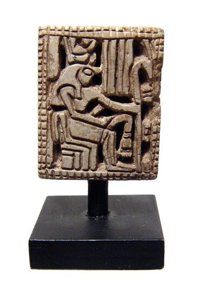 An attractive Egyptian steatite plaque: An attractive Egyptian steatite plaque, Late Period, c. 664 - 332 BC, the front with and openwork image of enthroned Horus holding a sceptre, the back with amuletic cartouche of Thutmose III amidst lo