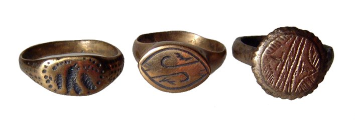 A lot of 3 ancient bronze rings: A lot of 3 ancient bronze rings. The first is Celtic, c. 300 - 100 BC, with flat oval bezel containing an incised floral device, W: 2.2 cm, ring size about 9 1/2". The second a Roman legionary type, c
