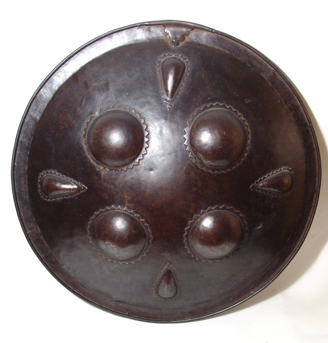 A very large Indo-Persian steel shield: A very large Indo-Persian steel shield, c. 18th Century or earlier, with attractive dark brown patination over profuse "kuftgari" (overlaid design) and incised decoration that covers the entire surfac