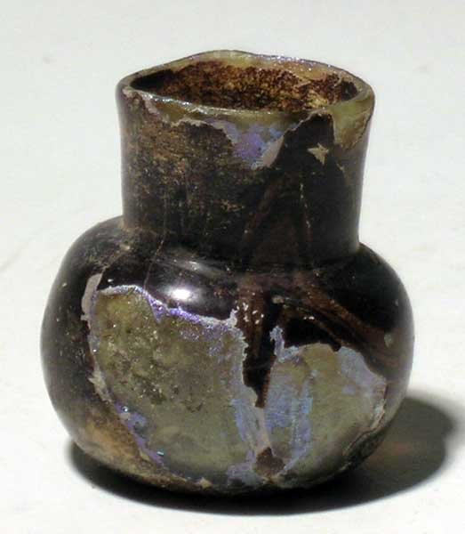 A lovely Roman glass bottle: A lovely Roman glass bottle, c. 1st – 3rd century AD. This beautifully formed cosmetics container is 1 ½ in (3.8cm) high and is covered with lovely iridescence. Choice example. Ex Freeman estate.
