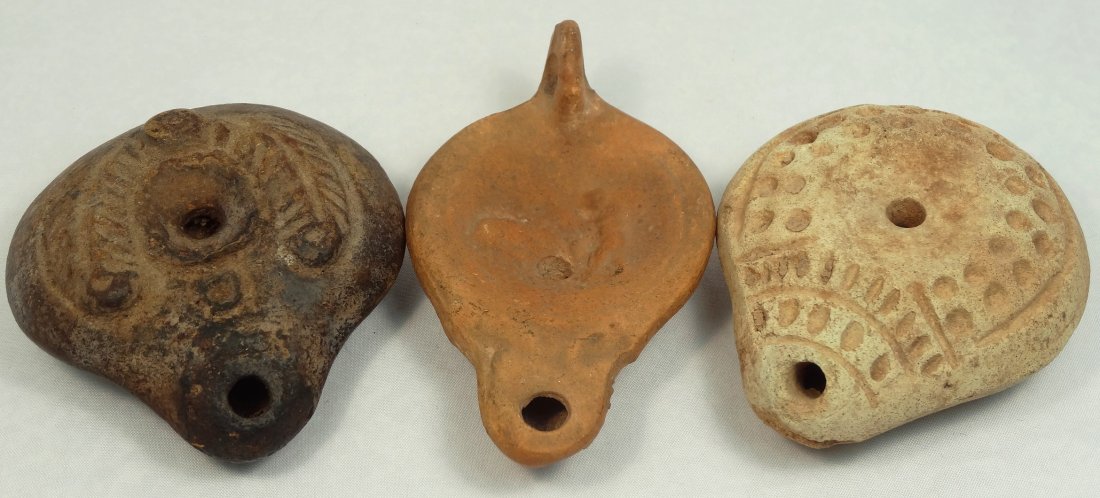 A lot of 3 ancient lamps: A lot of 3 ancient lamps. The first is a Roman discus lamp, c. 1st Century AD, with a male figure interacting with an animal within the discus, L: 4 in (10.1 cm). The second is a Roman Egypt classic '