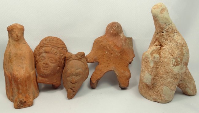 A lot of 5 ancient terracotta figures: A lot of 5 ancient terracotta figures. The first three are Graeco-Roman from Egypt, c. 2nd century BC/AD, including a votive mounted warrior, the head of a lady with a domed hairdo, and the head of a 