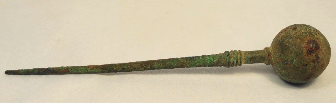 Egyptian bronze wig grooming tool: An Egyptian bronze wig grooming tool, New Kingdom, c. 1570-1075, with a large ball grip and some ribbing down the tool, L: 8 1/8 in (20.7 cm). This tool was used was used to both style and clean lappe