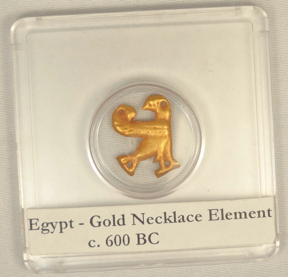 Egyptian pressed gold necklace element: An Egyptian pressed gold necklace element, 3rd Intermediate-Late Period, c. 1075-332 BC, in the form of a standing bird with its head turned back towards its wing, pierced with four small holes for at