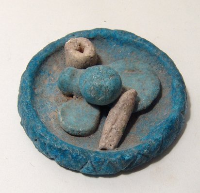 Egyptian faience votive offering dish: An Egyptian faience votive offering dish, Graeco-Roman, c. 2nd Century BC - 2nd Century AD, containing food offerings of bread and fruit. Dia: 2 ½ in (6.4 cm). Intact with great color and light depos