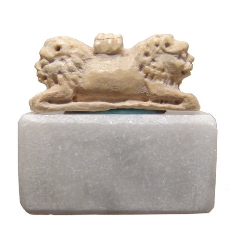 An Egyptian bone amulet of Aker, double-bodied lion: An Egyptian bone amulet of Aker, the double-bodied lion, New Kingdom, c. 1570 - 1075 BC, nicely carved with excellent detail, suspension loop on back. L: 7/8 in (2.4cm). Amulets of Aker signified trav