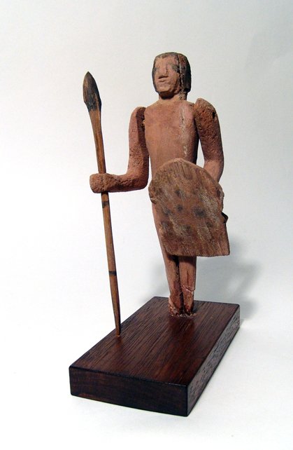 Egyptian wood figure of a Nubian soldier: An Egyptian wood figure of a Nubian soldier, idle Kingdom, c. 2040 - 1782 BC, holding a spear in one hand and a leopard skin shield in the other. Shield is ancient, but probably added later from anoth