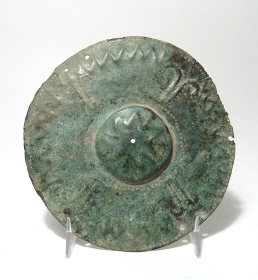 Etruscan/Villanovan decorated bronze shield boss: An Etruscan/Villanovan decorated bronze shield boss, c. 8th - 7th Century BC, of circular form, with raised center, the entire piece nicely adorned with incised and repousse relief. Dia: 5 3/4 in (14.