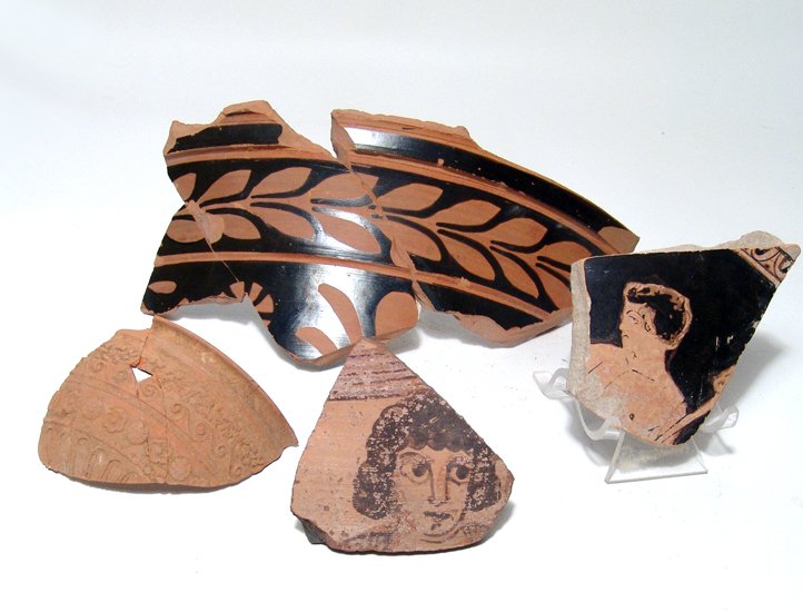 A group of attractive painted pottery fragments: A group of attractive painted pottery fragments. Lot includes a sherd of a Coptic vessel from Egypt, c. 4th - 5th Century AD, with a facing male head in brown slip, the features handsomely rendered, (