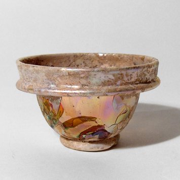 A Roman yellow glass cup: A Roman yellow glass cup, c. 3rd - 4th Century AD, with small disk foot, the collared rim with ridges and rounded rim. H: 1 3/4 in (4.5 cm); Dia: 3 1/4 in (8.3 cm). Deep yellow color and gorgeous irid