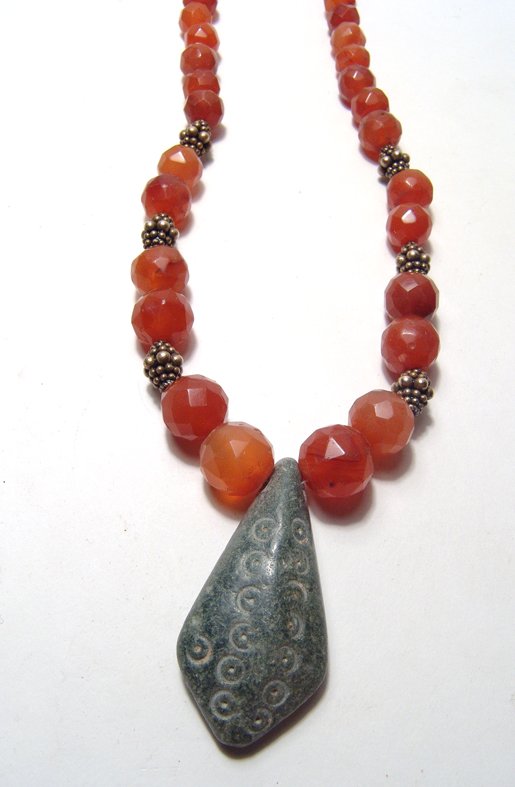 Necklace composed of Mesopotamian carnelian beads: A necklace composed of Mesopotamian carnelian beads and a steatite pendant, c. 2nd Millennium BC, the beads nicely faceted with deep red-orange color and finished with antique gold plated silver beads