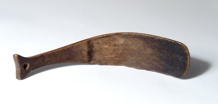 Inuit wood spoon from St. Lawrence Island: An attractive Inuit wood spoon from St. Lawrence Island, 17th - 19th Century, with a handle in the form of a whale's tail with central hole for suspension. L: 6 in (15.2 cm). Intact with a nice patina