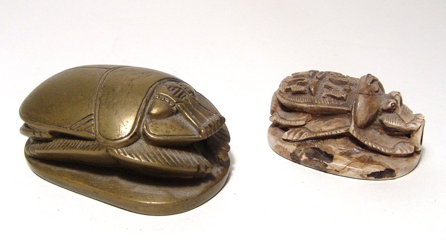 A pair of Egyptian Revival scarabs: A pair of Egyptian Revival scarabs, 1920's - 1930's, the first a large brass example of the famous commemorative scarabs of Amenhotep III and Queen Tiye, quite solid with a naturalistic look and attra