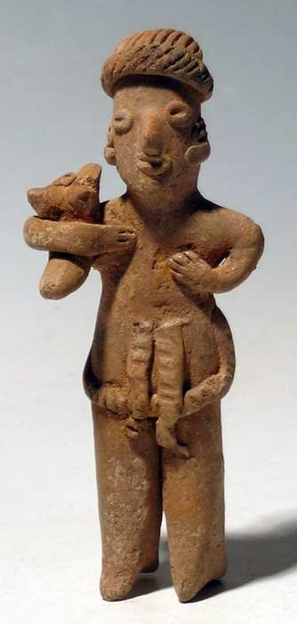 Excellent Colima figure from West Mexico, Pre-Columbian: An excellent Colima figure from West Mexico, c. 300 BC - 300 AD. This adorable example is 5 in tall and depicts a man holding a puppy over his right shoulder. He is wearing an intricately incised head