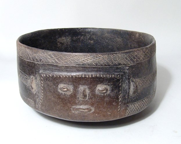A large Colima black-ware bowl, PreColumbian: A large Colima black-ware bowl, Mexico, c. 300 BC - AD 300, nicely burnished, a humanoid face on each side joined by three incised parallel bands. Dia: 8 1/2 in (21.6 cm); H: 4 3/4 in (12.1 cm). Few m