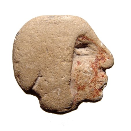 Mayan limestone inlay in the form of a male head: A Mayan limestone inlay in the form of a male head, c. AD 400 - 600, wearing a close fitting headdress, the face with remains of reddish pigment. 27 x 27mm. Ex J.L. Malter collection.