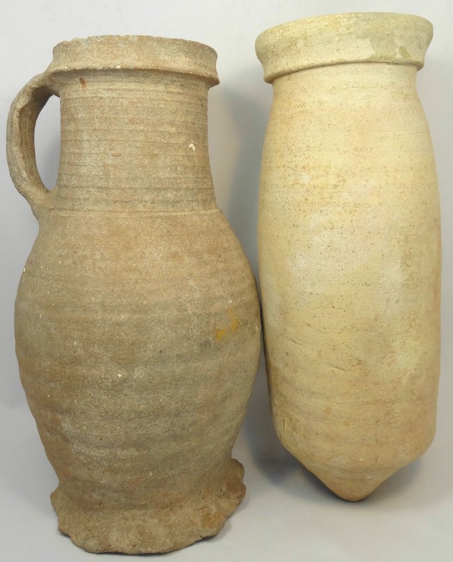 A lot of 2 large terracotta vessels: A lot of 2 large terracotta vessels. The first a nice grey buff Byzantine cylindrical vessel, c. 4th - 5th Century AD, with pointed base, the neck slightly tapered with collared mouth. H: 9 5/8 in (24