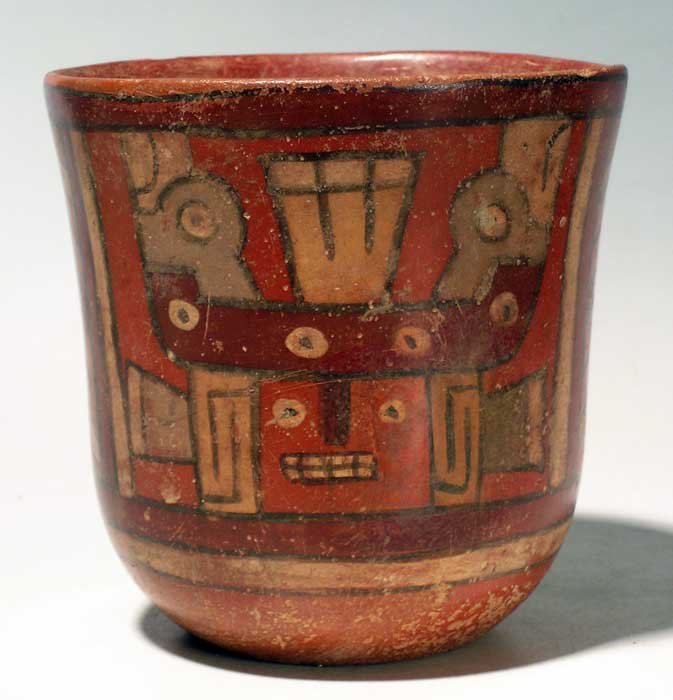 Fine Huari polychrome jar from Peru: A fine Huari polychrome jar from Peru, c. 650 – 800 AD. This fine beaker with flared rim is 4 in high and features two depictions of a deity wearing a complex headdress studded with a pair of condor