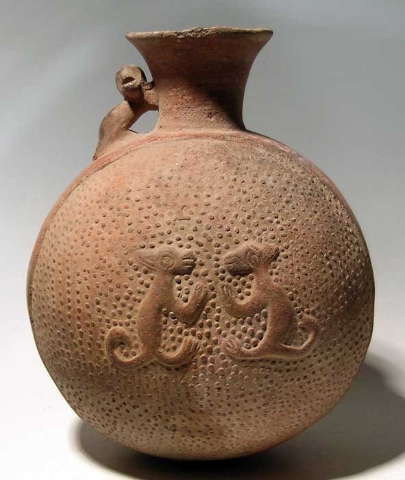 Chimu-Inca bottle from Peru: An excellent Chimu-Inca bottle from Peru, c. 1300 – 1450 AD. This fine orangeware vessel is 9-3/4 in high and features a confronted pair of playful foxes on each side of the chamber. A large monkey 