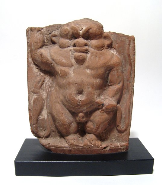 Egyptian plaque or cippus depicting Bes: A large Egyptian terracotta plaque or cippus depicting Bes, Ptolemaic, c. 2nd - 1st Century BC, grasping a snake in one hand, and another snake to his opposite side. H: 6 1/8 in (15.7cm), W: 4 7/8 in 