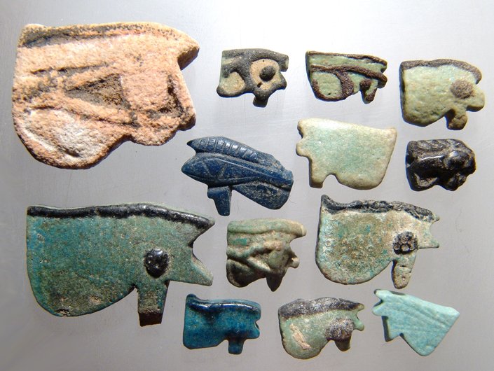 A lot of 13 Egyptian faience amulets: A lot of 13 Egyptian faience amulets, ‘Eye of Horus’ amulets, eight examples date from the 3rd Intermediate Period, c. 1075 - 760 BC, with black cosmetic details, and five from the Late Period, c.