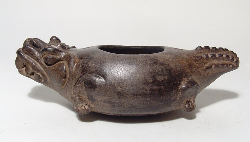 Mayan vessel in the form of a crocodile: A lively Mayan vessel in the form of a crocodile, c. AD 600 - 900, with fierce countenance, the body hollow with rounded bottom, a perforation on either side of the opening, probably for attachment of