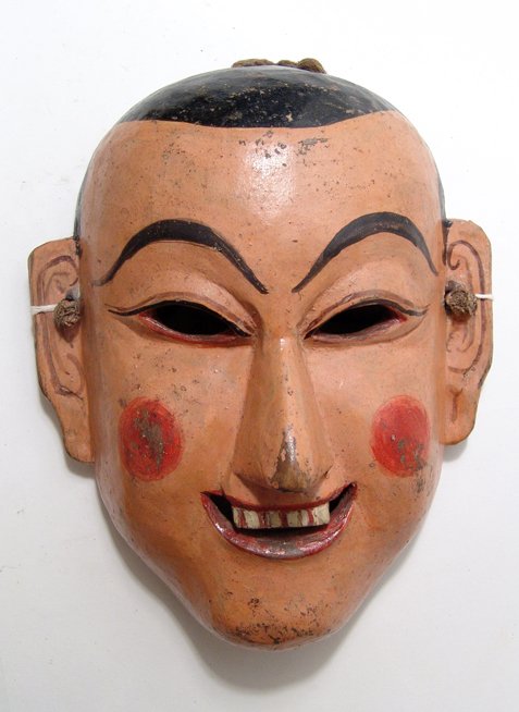 Polychromed wood mask of a lama: An attractive polychromed wood mask of a lama, Bhutan, early 20th Century, flesh-colored with pink cheeks. L: 8 ¾ in (22.2 cm). Some wear from use. A pleasing example! Ex Tan young, Katmandu, Nepal.