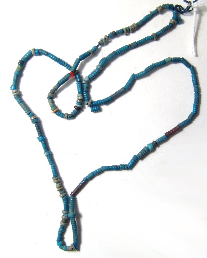 An Egyptian faience beaded necklace: An Egyptian faience beaded necklace, Late Period, c. 664 - 30 BC, composed of faience disc and tube beads with vibrant color. L: 21 in (53.2 cm). Strung on modern cord without clasp. Ex private Britis