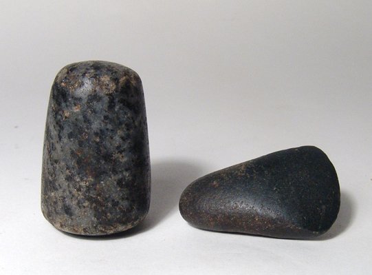 Egyptian axe-head and stone pestle: An Egyptian Pre-Dynastic axe-head and an early Dynastic stone pestle. The axe-head is in basalt, c. 4,000 - 3,000 BC, and nicely shaped with near polished surfaces and well-preserved cutting edge. (L: