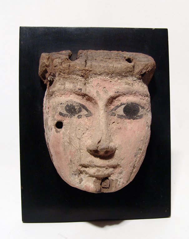 Egyptian painted wood mask, c. 1075 - 343 BC: A lovely Egyptian painted wood mask, 3rd Intermediate to Late Period, c. 1075 - 343 BC, the face painted a pinkish color with finely carved features, the eyes and brows detailed in black as is the vis