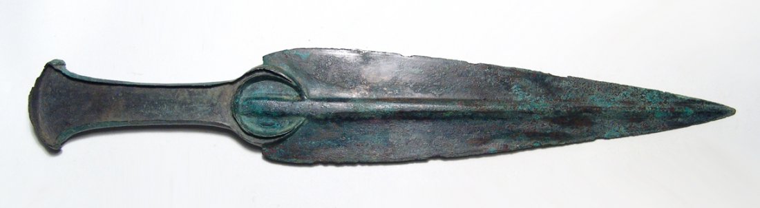 A nice Near Eastern bronze dagger: A nice Near Eastern bronze dagger, c. 1000 - 800 BC, the blade and hilt cast as a single piece. The flanged hilt with wedge-shaped pommel, once holding inlays, the blade rounded at the shoulders with 