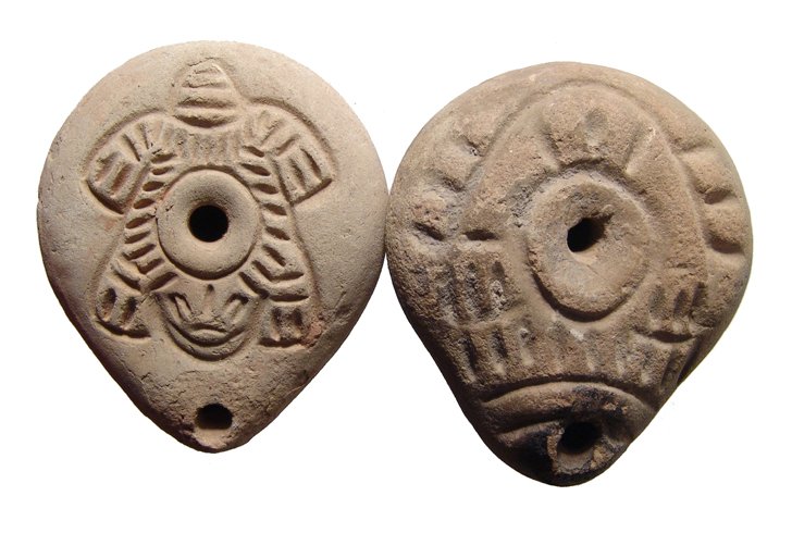 A pair of Roman ‘Frog’ lamps from Egypt: A pair of Roman ‘Frog’ lamps from Egypt, c. 3rd - 4th Century AD, both of lentoid shape and each with a stylized frog on top, one a bit more stylized than the other, and both with symbols stamped 