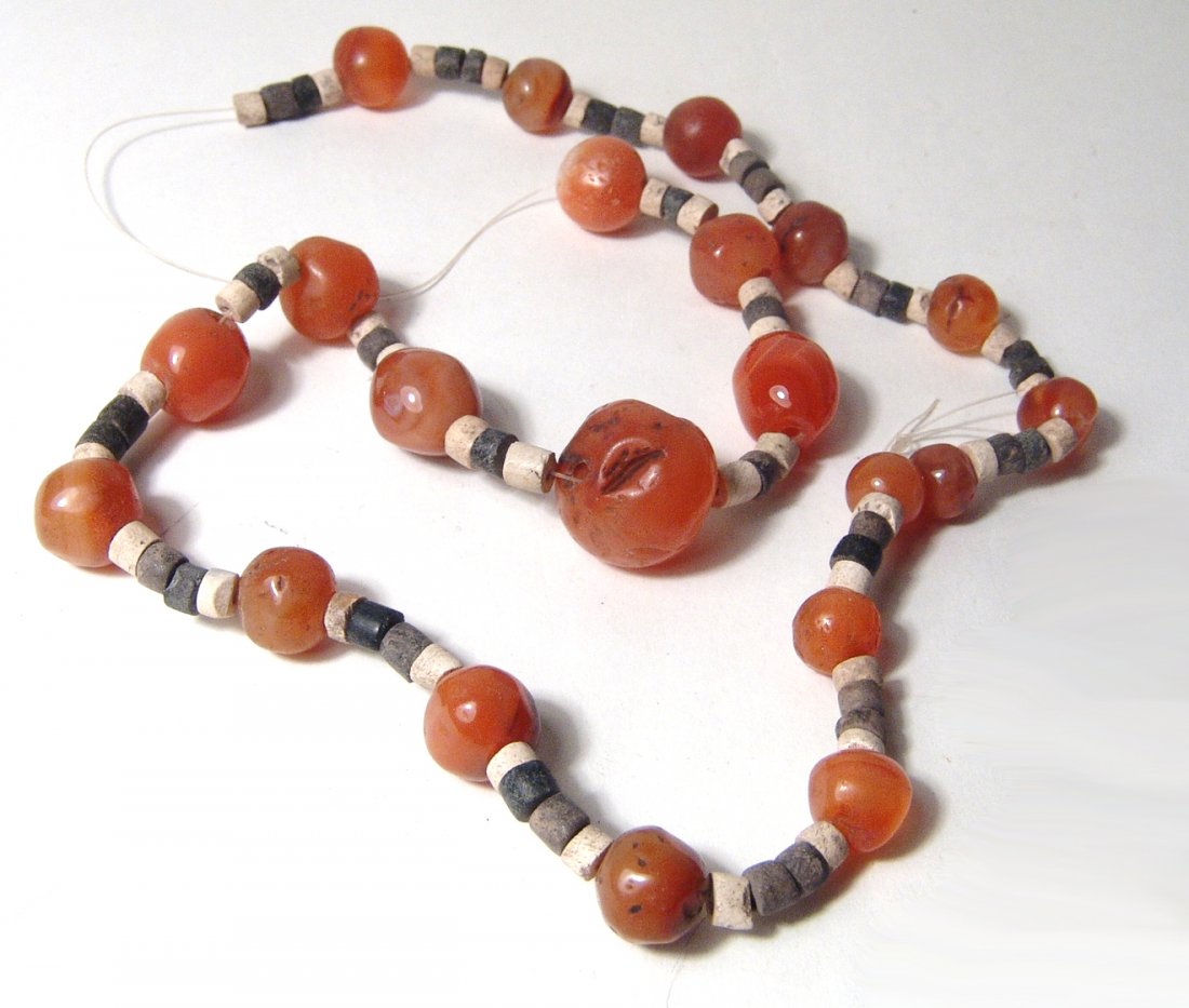 Strand of ancient Levantine and Sumerian stone beads: A strand of ancient Levantine and Sumerian stone beads. Strand includes rounded carnelian beads, Levantine, c. 1st Millennium BC, each roughly shaped by hand and polished, showing nice color and trans