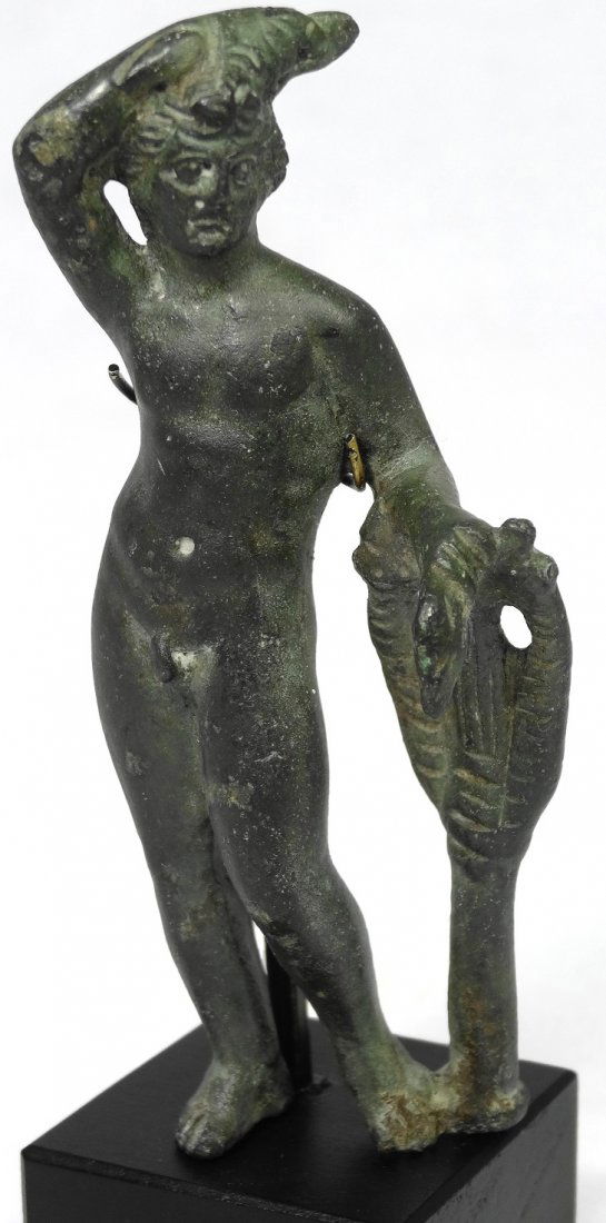 A Roman bronze figure of nude Apollo: A Roman bronze figure of nude Apollo, c. 1st-2nd Century AD, standing with his weight on his right leg, his right arm raised atop his head, and the left arm leaning upon a kithara, which is standing u