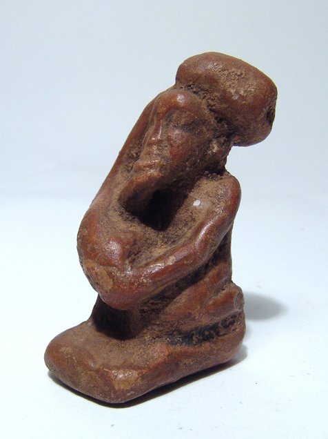 Egyptian ceramic figure of an ithyphallic dwarf: An Egyptian ceramic figure of an ithyphallic dwarf, Graeco-Roman, c. 3rd - 1st Century BC, depicted kneeling with enormous penis wrapped over left shoulder, right hand under his chin. AN interesting p