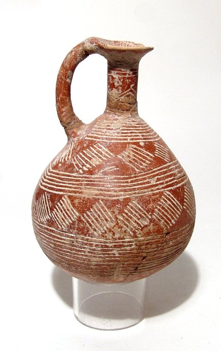 Cypriot Red Polished Ware Juglet: A nice Cypriot Red Polished Ware Juglet, Early Cypriot III - Middle Cypriot I, c. 1900 - 1650 BC, decorated with glossy red slip and bands of incised decoration. The body is piriform in shape with nar
