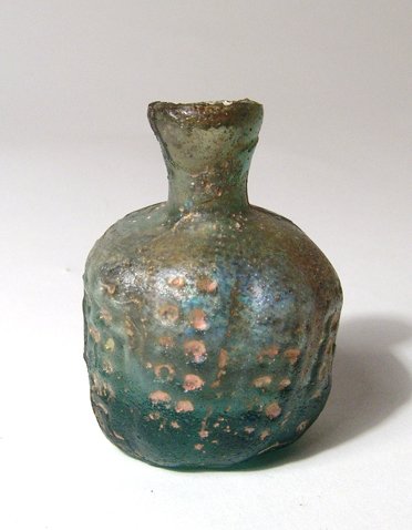 A pale blue-green Islamic glass jar: A pale blue-green Islamic glass jar, c. 7th - 9th Century AD, the body with wide vertical ridges, each with two rows of circular depression, the base is deeply indented and the constricted neck is sho