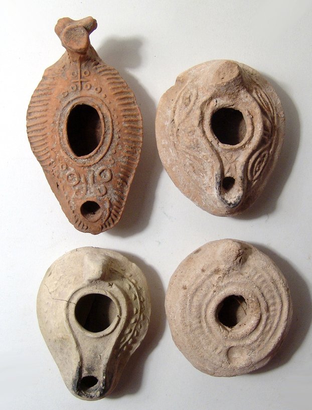 4 ancient ceramic lamps from the Holy Land: A lot of 4 ancient ceramic lamps from the Holy Land. Lot includes a Byzantine type, c, 7th - 8th Century AD, with laurel-wreath around shoulders, raised channel connecting fill-hole and wick-hole, pin