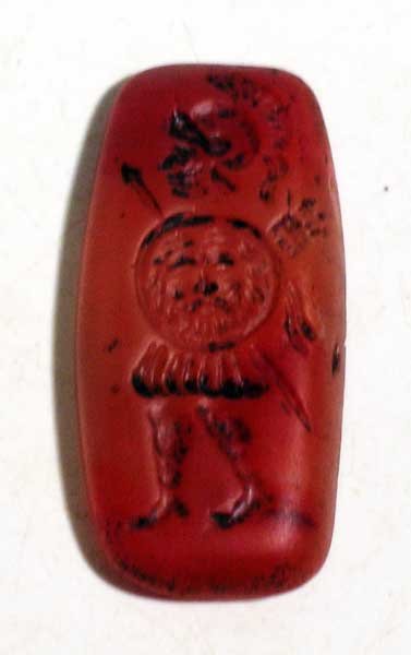 A choice Sasanian seal: A choice Sasanian seal, c. 224 – 651 AD. It is 1-5/8 in long and depicts a heavily armed warrior carrying a shield adorned with the head of a deity. Carved from translucent carnelian. Expected wear 