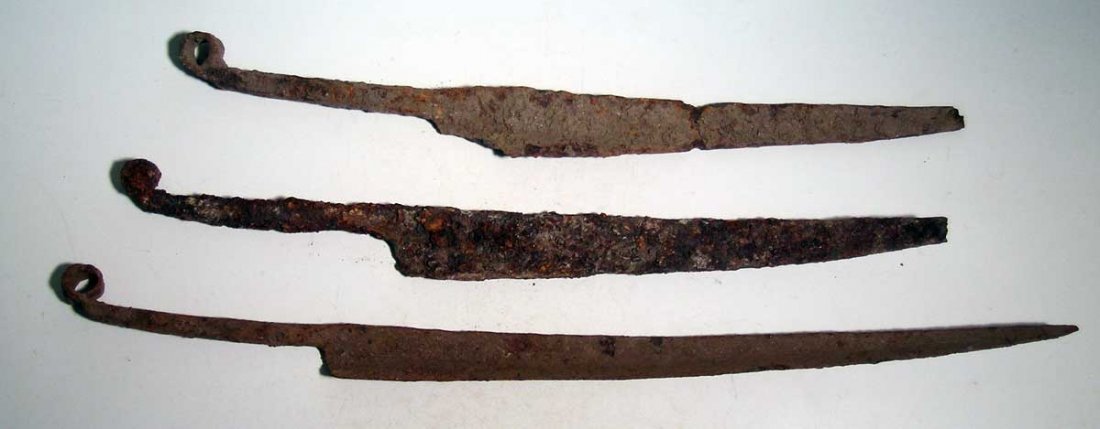 A trio of Kushan blades, c. 1st – 4th century AD: A trio of Kushan blades, c. 1st – 4th century AD. These curved weapons are 15 in – 18 in long and are made from iron. Each handle terminates in a curled end.